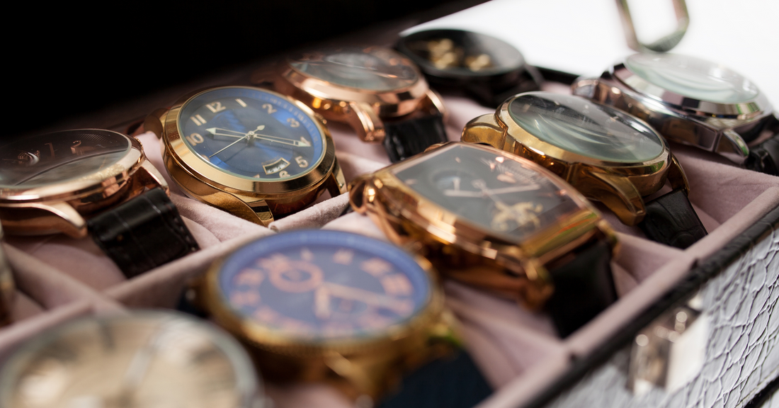Collection of stylish mini watches with gold and leather straps displayed in a case